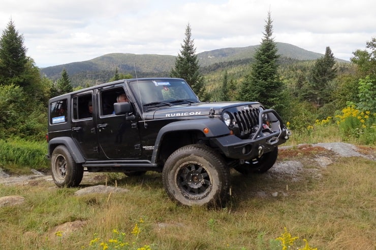 Michelin Defender LTX M/S tires on a black Jeep Wrangler Rubicon off roading